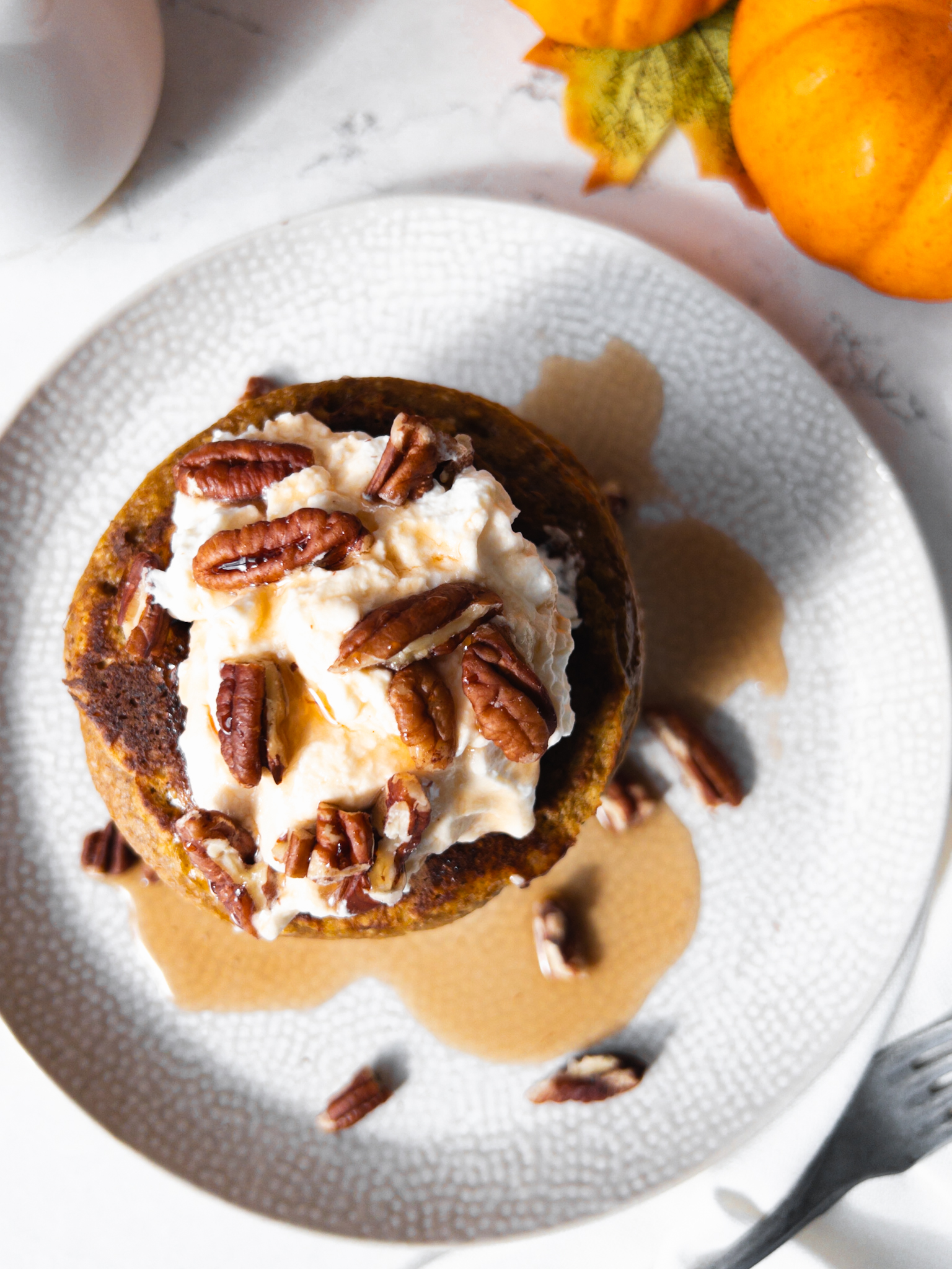Pumpkin Spice Oat Pancakes with cream pecans and maple syrup