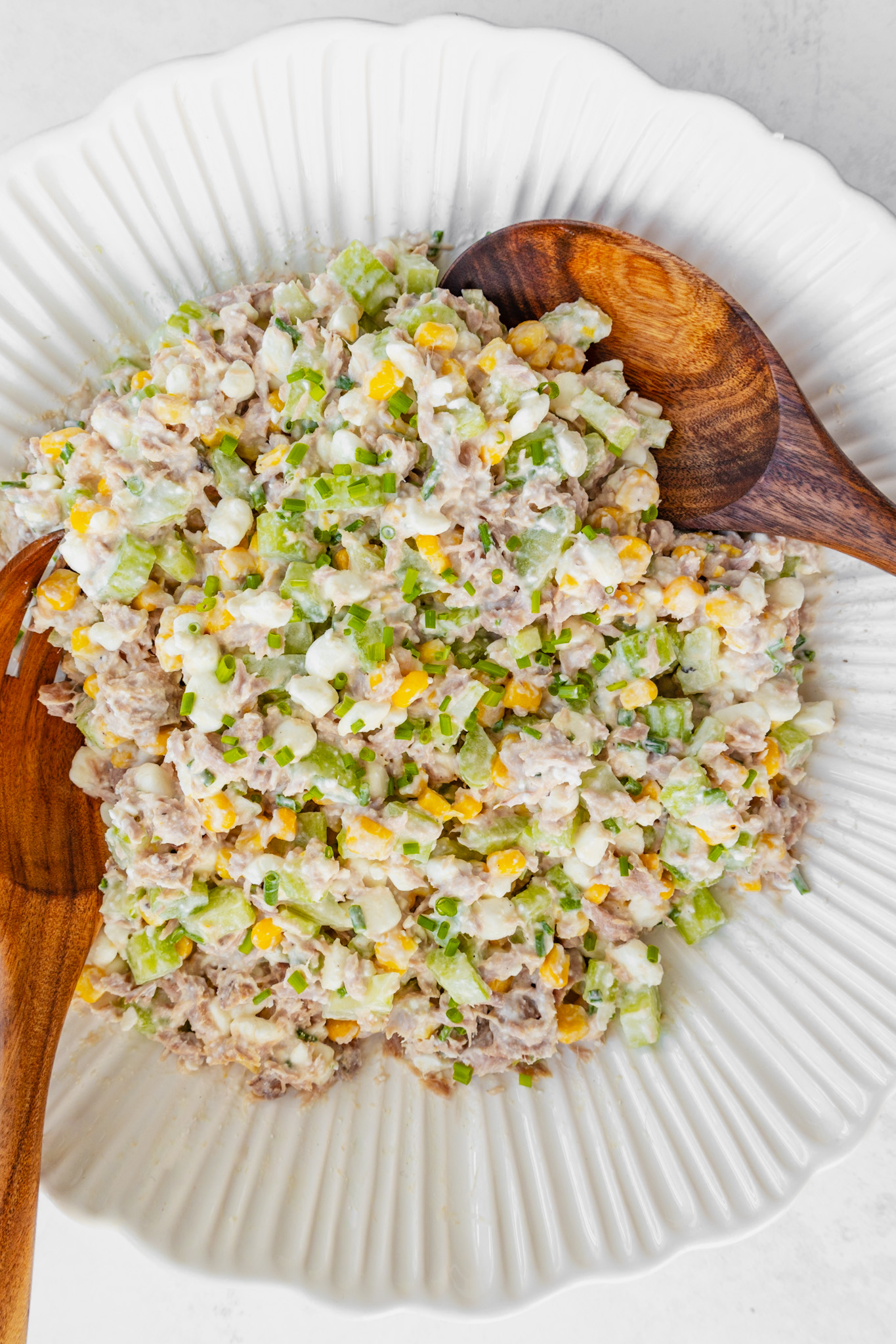 Serving bowl with tuna cottage cheese, sweetcorn, celery salad, and salad servers