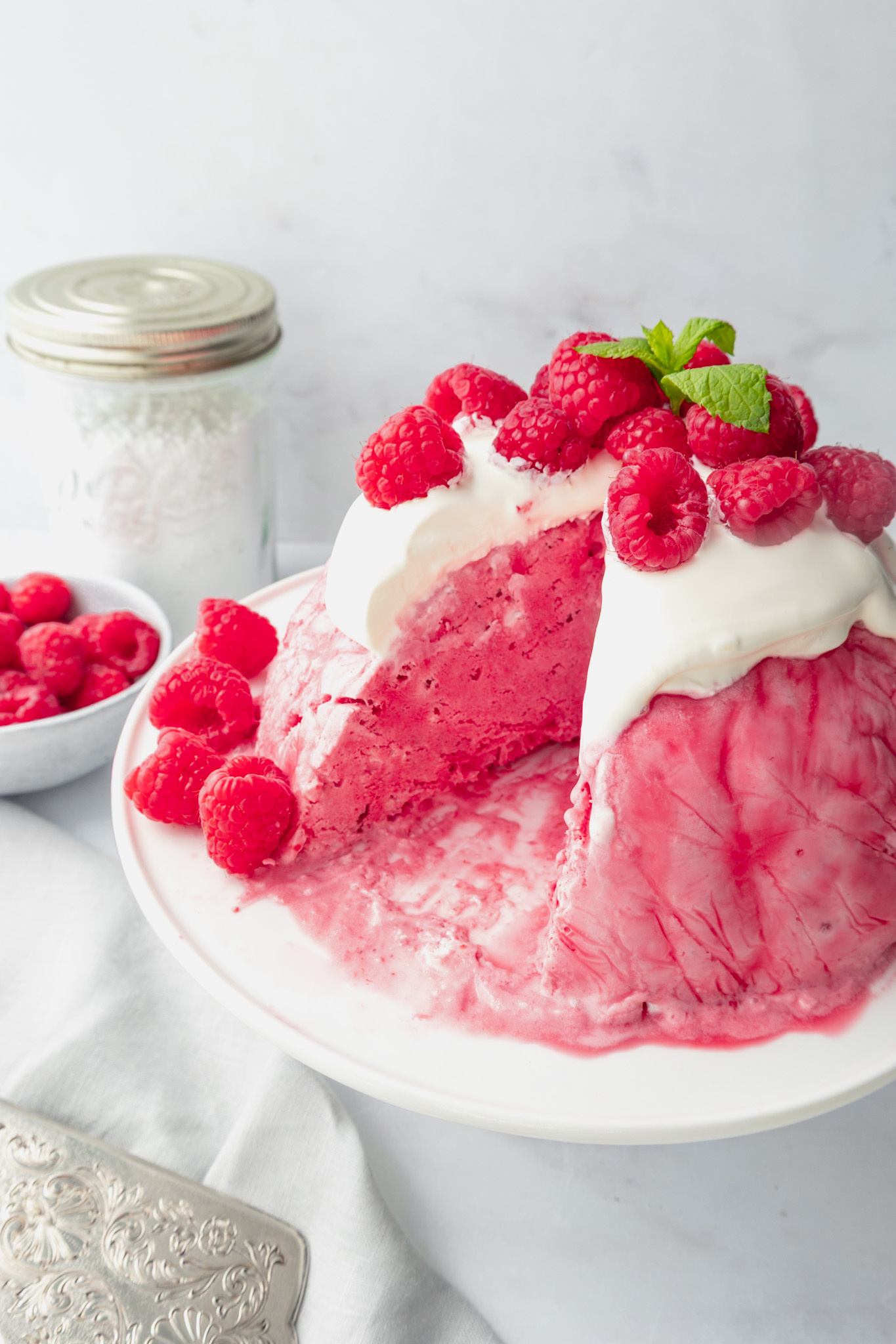 Raspberry ice cream bombe topped with creme fraiche, fresh raspberries and mint