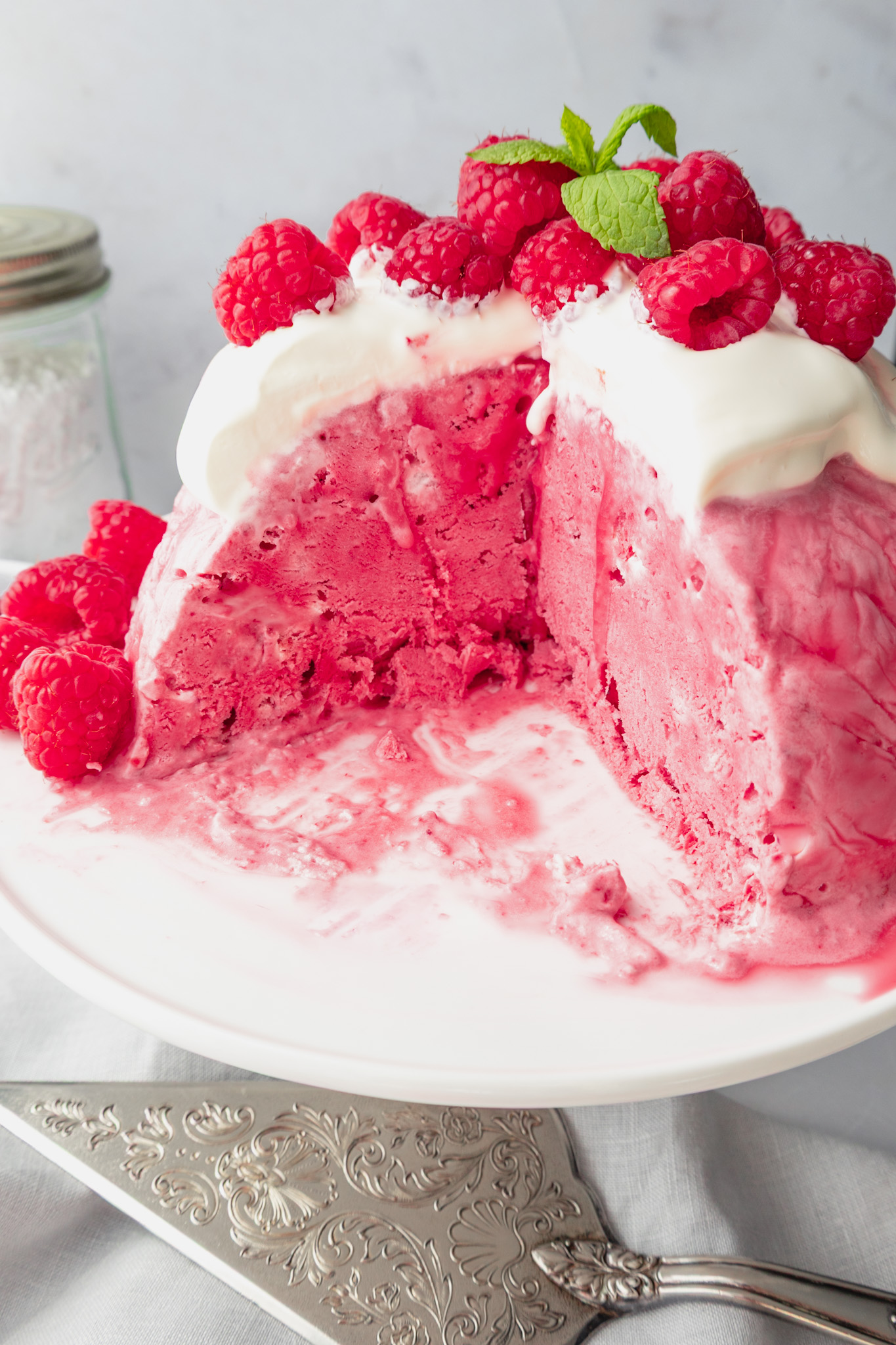 Raspberry ice cream bombe topped with creme fraiche, fresh raspberries and mint