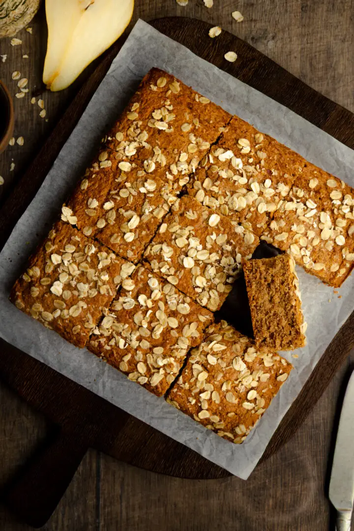 Pear Breakfast Cake sprinkled with oats on a chopping board
